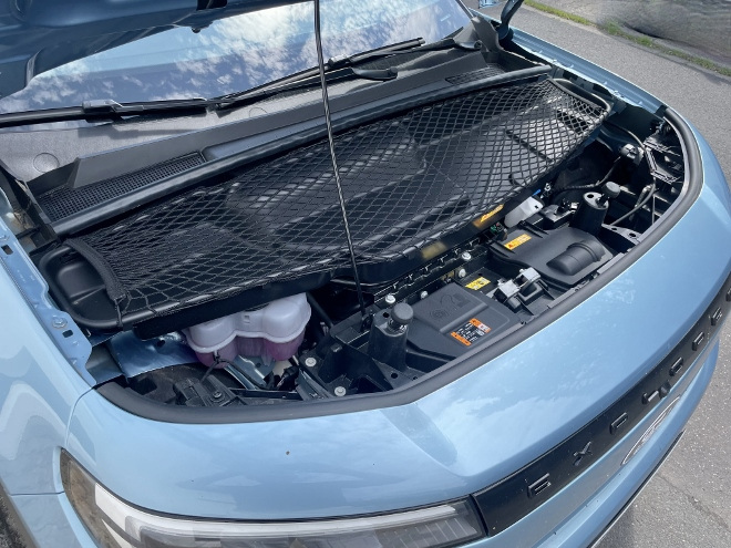 Ford Explorer Extended Range mit Batterie mit 79 kWh Kapazität im Test: vorderer Motor. Darüber eine Ablage mit Netz