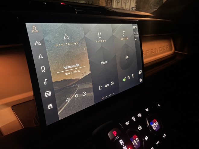 Land Rover Defender Langversion 130 D300 AWD Touchscreen bildschirm, nachts bei Dunkelheit, Menüs für Navigation, Telefon und Medien, direktesten Links am Rand des Bildschirm
