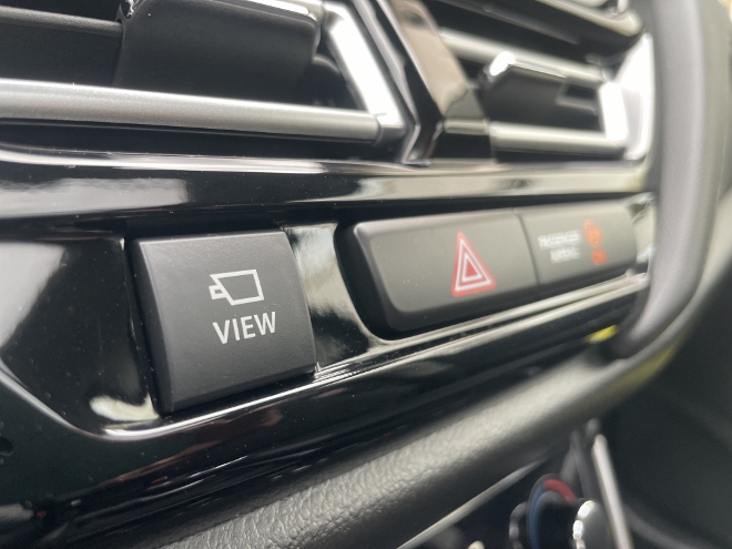 Suzuki S-Cross Hybrid 4x4 mit Schaltgetriebe: Taste für die Kameraansicht unter den Luftdüsen im Cockpit