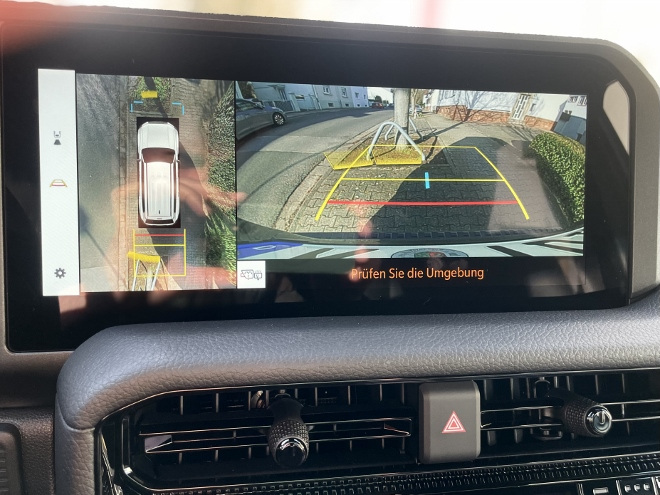 Test Toyota Land Cruiser Executive 2.8 Diesel: zweigeteiltes Bild der Rückfahrkamera und das 360° Rundumsichtsystem auf dem Bildschirm. Aus der Vogelperspektive und Heck Kamera